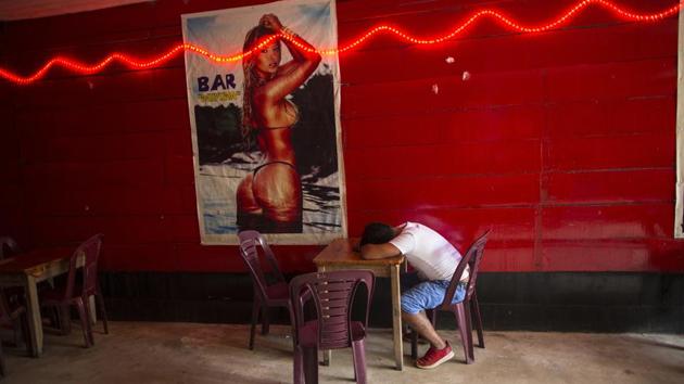 A client sits passed out at the Nectar del Olvido bar. Zabala says his congregation of miners is unlikely to welcome Pope Francis’ message on protecting the Amazon. Francis likened the rainforest to one of the “lungs of our planet” that must be preserved. “It’s easy to talk from Lima or Rome,” said Zabala, a biology graduate who turned to the church. “But what will these people eat if they’re kicked out?” (Rodrigo Abd / AP) A client sits passed out at the Nectar del Olvido bar. Zabala says his congregation of miners is unlikely to welcome Pope Francis’ message on protecting the Amazon. Francis likened the rainforest to one of the “lungs of our planet” that must be preserved. “It’s easy to talk from Lima or Rome,” said Zabala, a biology graduate who turned to the church. “But what will these people eat if they’re kicked out?” (Rodrigo Abd / AP)