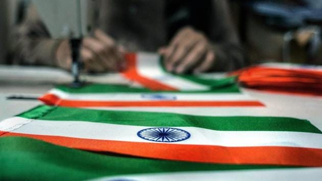 A tailors stitches together a national flag at his workshop ahead of Republic Day, in New Delhi. (PTI Photo) A tailors stitches together a national flag at his workshop ahead of Republic Day, in New Delhi. (PTI Photo)