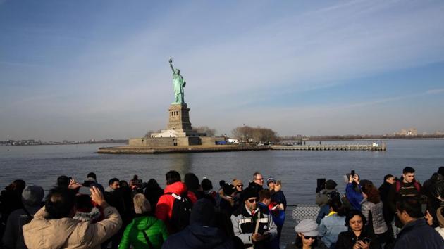 People take pictures as they to go around the Statue of Liberty on Sunday in New York City. (AFP) People take pictures as they to go around the Statue of Liberty on Sunday in New York City. (AFP)