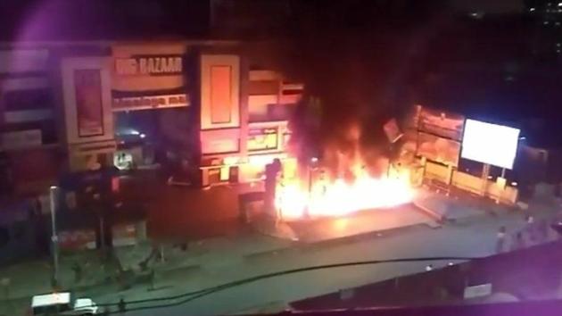 Protesters set fire to vehicles and property outside the Himalaya Mall in Ahmedabad on Tuesday.(HT Photo)