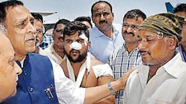 Gujarat chief minister Vijay Rupani interacts with Sheikh Saleem Gafur, the driver of the bus, after the attack. (PTI file photo)