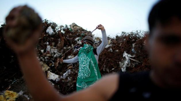 A protester nicknamed Abu Akram, wearing a Hamas flag and protesting the Israeli blockade of Gaza, holds a sling during clashes with Israeli troops. While Hamas, Fatah and other groups call for weekly shows of strength on Fridays, dozens of stonepelters turn out along the border with Israel every day, even when, as last Friday, a protest is called off due to bad weather. (Mohammed Salem / REUTERS) A protester nicknamed Abu Akram, wearing a Hamas flag and protesting the Israeli blockade of Gaza, holds a sling during clashes with Israeli troops. While Hamas, Fatah and other groups call for weekly shows of strength on Fridays, dozens of stonepelters turn out along the border with Israel every day, even when, as last Friday, a protest is called off due to bad weather. (Mohammed Salem / REUTERS)