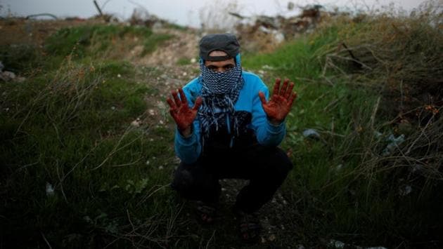 A Palestinian protester, nicknamed Abu Jaber, shows hands stained with the blood of a wounded friend during clashes with Israeli troops. “We protest against the crazy decision made by Trump on Jerusalem and against the hardship we have experienced for more than 10 years due to the Israeli blockade. I hope the blood which you can see on my hands will move the Arab and Muslim world to revolt against Israel and America,” he said. (Mohammed Salem / REUTERS) A Palestinian protester, nicknamed Abu Jaber, shows hands stained with the blood of a wounded friend during clashes with Israeli troops. “We protest against the crazy decision made by Trump on Jerusalem and against the hardship we have experienced for more than 10 years due to the Israeli blockade. I hope the blood which you can see on my hands will move the Arab and Muslim world to revolt against Israel and America,” he said. (Mohammed Salem / REUTERS)