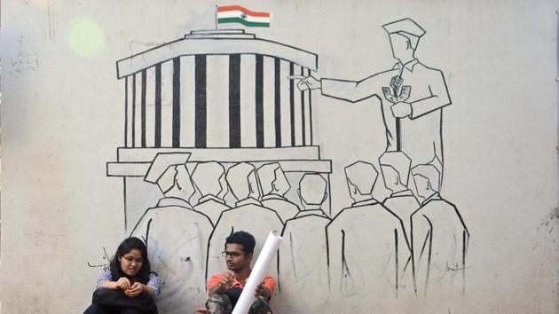 Students of SP College sit beneath a mural which depicts the parliament of India, ahead of Republic Day, on Tuesday. (Shankar Narayan/HT PHOTO) 