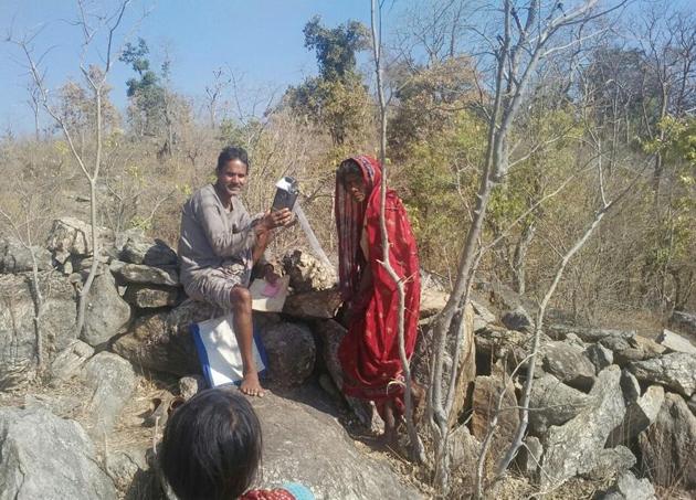 A public distribution system (PDS) dealer with a POS (point of sale) machine and a PDS beneficiary atop a hill due to poor internet connectivity at Rewat Khurd village in Latehar district of Jharkhand. (Vishal Sharma / HT Photo) A public distribution system (PDS) dealer with a POS (point of sale) machine and a PDS beneficiary atop a hill due to poor internet connectivity at Rewat Khurd village in Latehar district of Jharkhand. (Vishal Sharma / HT Photo)
