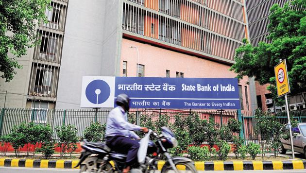 A file photo of a man riding past an SBI branch in New Delhi.(Mint)