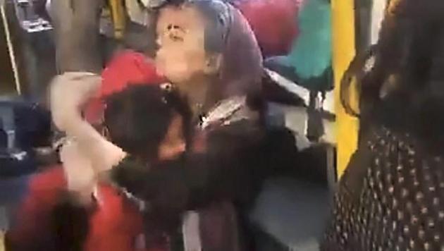 (Video grab) A woman hugs a child crouched on the floor of the GD Goenka World School bus in Gurgaon on Wednesday.(PTI)