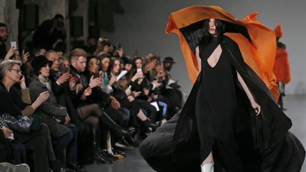 A model walks the runway during Hyun Mi Nielsen’s migration and magpie inspired spring/summer show that used large flapping straps, bits like anklets, shells and billowing coats on barefoot models. (Thierry Chesnot / Getty Images) A model walks the runway during Hyun Mi Nielsen’s migration and magpie inspired spring/summer show that used large flapping straps, bits like anklets, shells and billowing coats on barefoot models. (Thierry Chesnot / Getty Images)