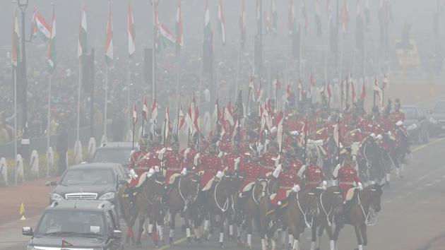 President's horse mounted bodyguards are seen through the morning fog as they escort the President arriving for the Republic Day parade in New Delhi.(AP Photo)