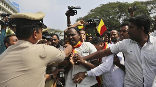 A police officer pushes a pro-Kannada activist who tried stopping traffic during a dawn-to-dusk strike in Bangalore on January 25. (AP Photo) A police officer pushes a pro-Kannada activist who tried stopping traffic during a dawn-to-dusk strike in Bangalore on January 25. (AP Photo)