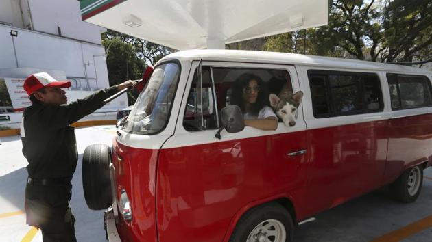 Jair Benavides has his Volkswagen van fuelled at a gas station as he takes the dogs on a day trip. They take their dozens of dogs out on field trips outside the city so that they can exercise and roam free in nature. (Marco Ugarte / AP) Jair Benavides has his Volkswagen van fuelled at a gas station as he takes the dogs on a day trip. They take their dozens of dogs out on field trips outside the city so that they can exercise and roam free in nature. (Marco Ugarte / AP)