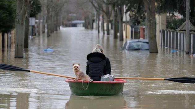 Local residents and their dog go down a flooded street in a rowboat in Villeneuve-Saint-Georges on January 24, 2018. France braced for floods on January 23 as the Rhine threatened to overflow and the rapidly rising Seine forced Paris authorities to halt trains on a busy commuter line. Heavy rains have lashed France for days, leaving 30 departments across the country on flood alert. (Thomas Samson / AFP) Local residents and their dog go down a flooded street in a rowboat in Villeneuve-Saint-Georges on January 24, 2018. France braced for floods on January 23 as the Rhine threatened to overflow and the rapidly rising Seine forced Paris authorities to halt trains on a busy commuter line. Heavy rains have lashed France for days, leaving 30 departments across the country on flood alert. (Thomas Samson / AFP)