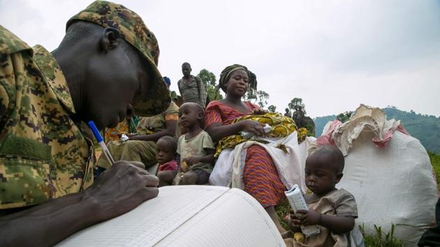 People are registered by an Ugandan soldier after they crossed the border from the Democratic Republic of Congo to become refugees at Nteko village in western Uganda on January 24, 2018. Since last December, about 300 Congolese people per day have been fleeing from the Mai Mai militias’ attacks in the Kivu region of the eastern part of DRC to this border area. (Sumy Sadurni / AFP) People are registered by an Ugandan soldier after they crossed the border from the Democratic Republic of Congo to become refugees at Nteko village in western Uganda on January 24, 2018. Since last December, about 300 Congolese people per day have been fleeing from the Mai Mai militias’ attacks in the Kivu region of the eastern part of DRC to this border area. (Sumy Sadurni / AFP)