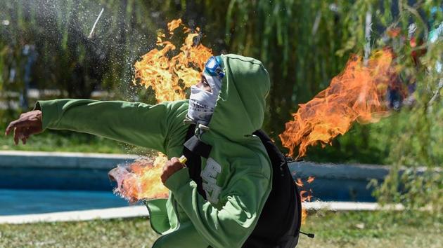 A demonstrator hurls a Molotov cocktail at the riot police during clashes in Caracas on January 22, 2018. (Juan Barreto / AFP) A demonstrator hurls a Molotov cocktail at the riot police during clashes in Caracas on January 22, 2018. (Juan Barreto / AFP)