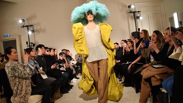 Pierpaolo Piccioli’s Valentino presentation opened to a wild clash of colours with a yellow faille coat, over brown work trousers and a simple tank. The giant aquamarine ostrich feather saucer hat gliding down the ramp as onlookers snapped away. (Pascal Le Segretain / Getty Images) Pierpaolo Piccioli’s Valentino presentation opened to a wild clash of colours with a yellow faille coat, over brown work trousers and a simple tank. The giant aquamarine ostrich feather saucer hat gliding down the ramp as onlookers snapped away. (Pascal Le Segretain / Getty Images)