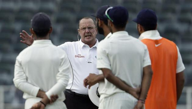 Umpire Michael Gough of England, facing camera, signals for the players to leave the field on the third day of the third cricket test match between South Africa and India at the Wanderers Stadium in Johannesburg.(AP)