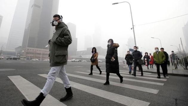 A man wearing a respiratory protection mask walks toward an office building during the smog after a red alert was issued for heavy air pollution in Beijing's central business district, China, December 21, 2016.(Reuters File Photo)