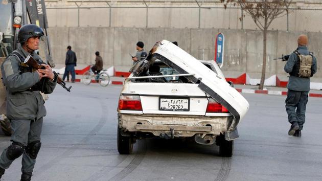 Police officers keep watch while a man drives his damaged car near the blast site. India on Saturday strongly condemned the “barbaric and dastardly” terrorist attack in Kabul targeting innocent civilians, and extended all possible assistance, including for treatment of the injured. (Omar Sobhani / REUTERS)