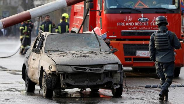 Police officers keep watch while a man drives his heavily damaged car at a car bomb attack site in Kabul, Afghanistan January 27, 2018. (REUTERS) Police officers keep watch while a man drives his heavily damaged car at a car bomb attack site in Kabul, Afghanistan January 27, 2018. (REUTERS)
