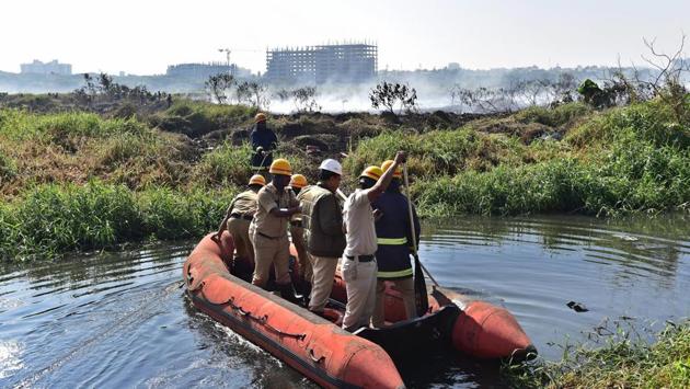 Firefighters inspecting the Bellandur lake in Bengaluru on Saturday. The lake, known for its high levels of pollution, caught fire on recently, sending out huge clouds of smoke on the Yemlur side.(PTI) Firefighters inspecting the Bellandur lake in Bengaluru on Saturday. The lake, known for its high levels of pollution, caught fire on recently, sending out huge clouds of smoke on the Yemlur side.(PTI)