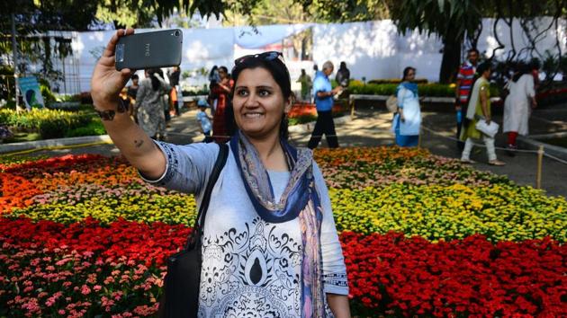 A woman takes a selfie with the decorated flowers at a flower show held in Empress Garden on Thursday, January 25. Families came in large numbers to see the beautiful floral decorations and set of exotic flowers at the show on January 26. (Shankar Narayan/HT PHOTO) A woman takes a selfie with the decorated flowers at a flower show held in Empress Garden on Thursday, January 25. Families came in large numbers to see the beautiful floral decorations and set of exotic flowers at the show on January 26. (Shankar Narayan/HT PHOTO)