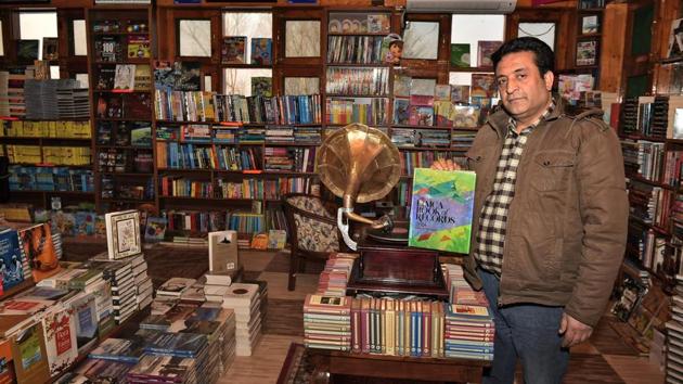 Aijaz Ahmad, 46, owner of Gulshan Books holds up the record book featuring his store. Reaching this one of a kind store is a shikara ride away from the banks of the Dal in Srinagar. (S Irfan / PTI) Aijaz Ahmad, 46, owner of Gulshan Books holds up the record book featuring his store. Reaching this one of a kind store is a shikara ride away from the banks of the Dal in Srinagar. (S Irfan / PTI)