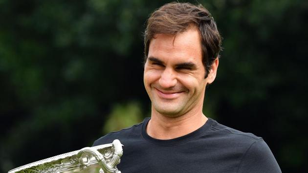 Switzerland's Roger Federer holds the Australian Open trophy at Government House as he poses for pictures following his win in Melbourne on Sunday.(AFP)