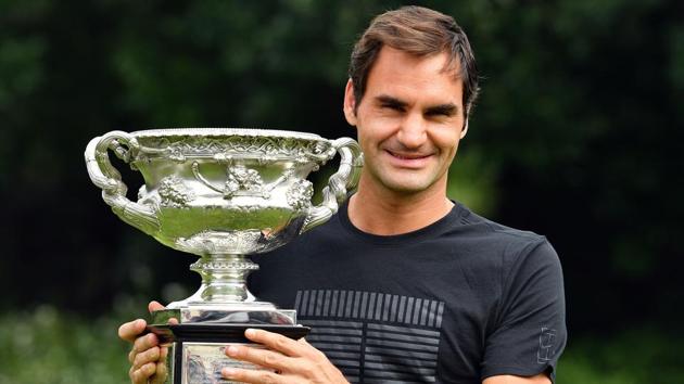 Switzerland's Roger Federer holds the Australian Open trophy at the Government House as he poses for pictures following his win in Melbourne on Sunday. (AFP)