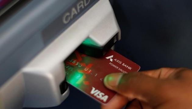 A man uses an Axis Bank automated teller machine (ATM) card. (Representative image) A man uses an Axis Bank automated teller machine (ATM) card. (Representative image)