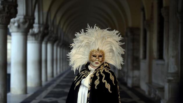 A masked reveller in a traditional carnival costume stands in St Mark Square. It was during the Renaissance that it became an official celebration, appealing to Italians because of the opportunities lent by the masks and parties to forget the rigid class system and the era’s daily concerns. (Filippo Monteforte / AFP) 