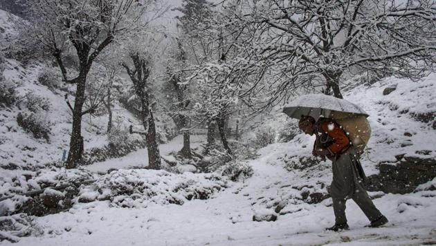 A man carrying a load on his back walks on a snow covered road in Baramulla district of Kashmir. An avalanche warning has been issued for several district. (PTI) A man carrying a load on his back walks on a snow covered road in Baramulla district of Kashmir. An avalanche warning has been issued for several district. (PTI)