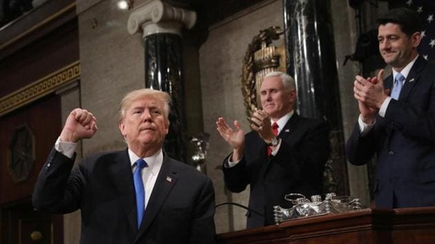 US President Donald Trump gestures at the podium in front of US Vice President Mike Pence (left) and Speaker of the House Paul Ryan during his first State of the Union address.(REUTERS)
