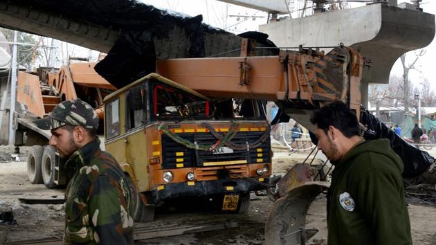 Police personnel inspect a girder of an under-construction flyover in Srinagar that collapsed after a 6.1 magnitude earthquake hit the city on Wednesday.(PTI)