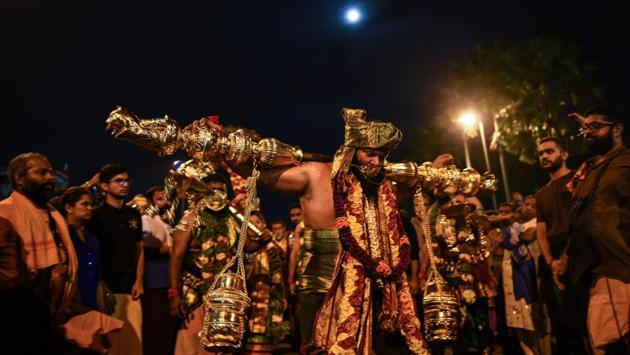 A man carries a “kavadi” balancing milk pots as offerings on his shoulder as he proceeds towards a temple in Kuala Lumpur. (Manan Vatsyayana / AFP) A man carries a “kavadi” balancing milk pots as offerings on his shoulder as he proceeds towards a temple in Kuala Lumpur. (Manan Vatsyayana / AFP)