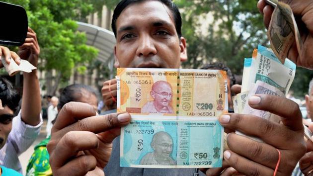 A man shows new currency notes of Rs 200 and Rs 50 outside the Reserve Bank of India in New Delhi on August 25, 2017. (PTI File Photo) A man shows new currency notes of Rs 200 and Rs 50 outside the Reserve Bank of India in New Delhi on August 25, 2017. (PTI File Photo)