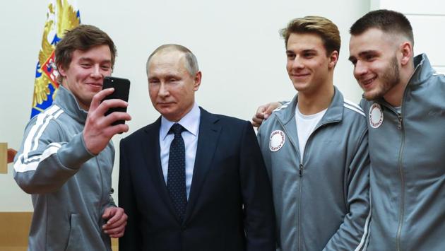 Russian president Vladimir Putin poses for a selfie with Russian athletes who will take part in the upcoming 2018 Pyeongchang Winter Olympics, at the Novo-Ogaryovo residence outside of Moscow on Wednesday.(AP)