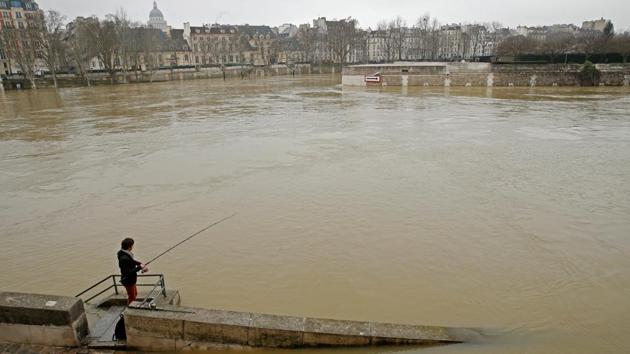 A man fishes on the flooded banks of the River Seine. Around 1,500 people have been evacuated from their homes in the greater Paris region while 1,900 households have lost electricity. Overall, Paris is better prepared than when it was last hit by floods in 2016, and Parisians have largely taken disruptions in stride. (Pascal Rossignol / REUTERS)