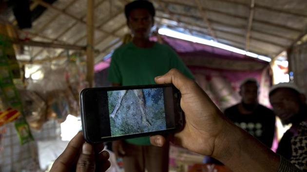 Mohammad Karim, a Rohingya Muslim refugee, shows a mobile video of Gu Dar Pyin's massacre inside his kiosk in Kutupalong refugee camp, Bangladesh. (AP Photo) Mohammad Karim, a Rohingya Muslim refugee, shows a mobile video of Gu Dar Pyin's massacre inside his kiosk in Kutupalong refugee camp, Bangladesh. (AP Photo)