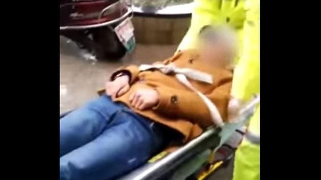 Paramedics lift the man and secure him to a stretcher