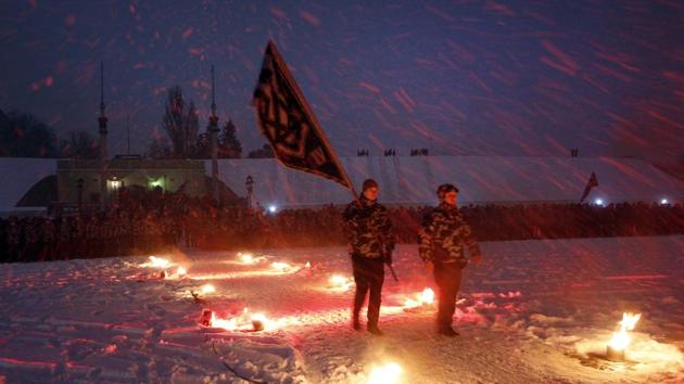 Volunteers of the right-wing paramilitary Azov Civil Corps carry their standard as they march along a fire path under a heavy snowfall at a swearing-allegiance ceremony in the yard of an old city fortress in central Kiev, Ukraine on January 28, 2018. (Efrem Lukatsky / AP) Volunteers of the right-wing paramilitary Azov Civil Corps carry their standard as they march along a fire path under a heavy snowfall at a swearing-allegiance ceremony in the yard of an old city fortress in central Kiev, Ukraine on January 28, 2018. (Efrem Lukatsky / AP)
