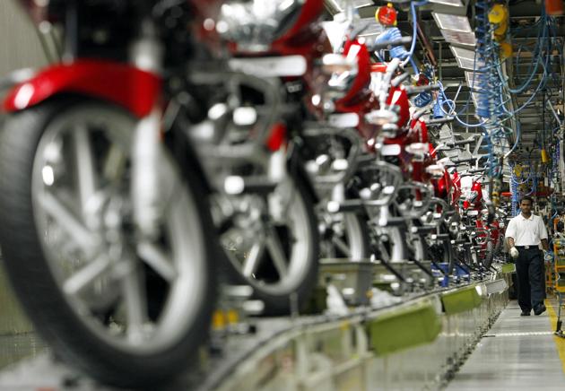 A worker walks beside newly built motorbikes at the Bajaj Auto Ltd. plant in Pune. (REUTERS)