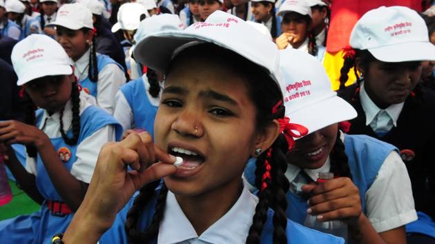 Students take a deworming tablet during a programme organised to mark National Deworming Day.(HT File Photo)
