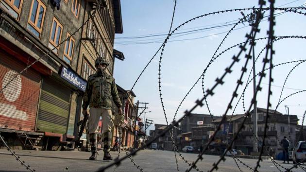 Security personnel guard a closed road during restrictions in Srinagar. (PTI) Security personnel guard a closed road during restrictions in Srinagar. (PTI)