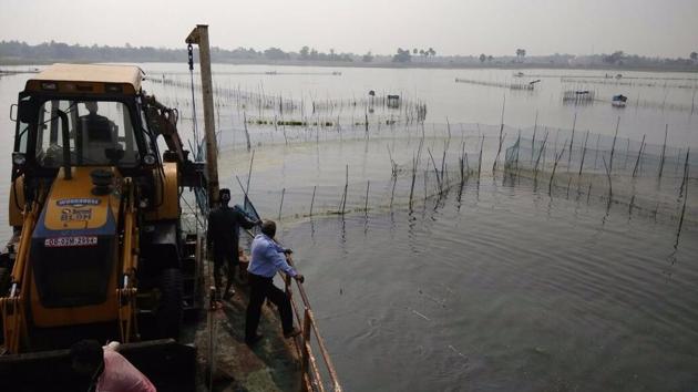 A barge-mounted excavator clearing the Chilika lake of illegal prawn farms. (HT Photo) A barge-mounted excavator clearing the Chilika lake of illegal prawn farms. (HT Photo)