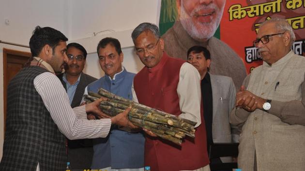 Chief minister Trivendra Singh Rawat accepts sugarcane from a farmer at a convention in Dehradun. (HT Photo) Chief minister Trivendra Singh Rawat accepts sugarcane from a farmer at a convention in Dehradun. (HT Photo)