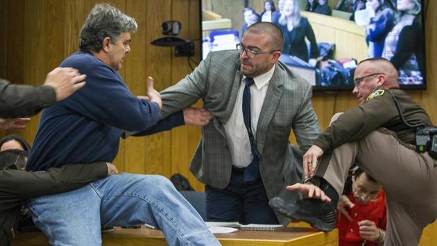 Randall Margraves (L), father of three victims of Larry Nassar (background R), lunges at Nassar in Eaton County Circuit Court in Charlotte. (AP) Randall Margraves (L), father of three victims of Larry Nassar (background R), lunges at Nassar in Eaton County Circuit Court in Charlotte. (AP)
