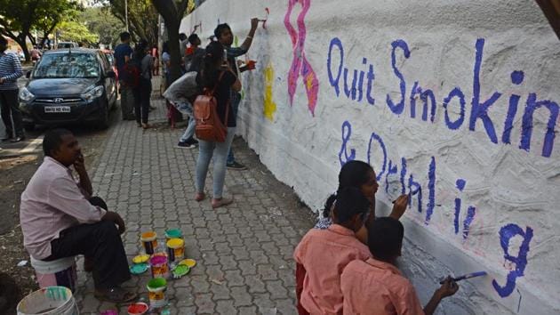Puneites paint city walls along with Indus Health Plus to create awareness about cancer in Pune on Saturday.(Shankar Narayan/HT PHOTO)