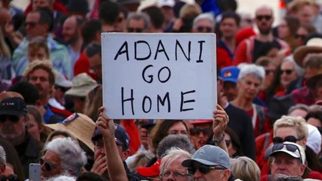 A protester holds a sign as he participates in a national Day of Action against Adani’s planned coal mine project in northeast Australia at Bondi Beach last October. (Reuters File Photo) A protester holds a sign as he participates in a national Day of Action against Adani’s planned coal mine project in northeast Australia at Bondi Beach last October. (Reuters File Photo)