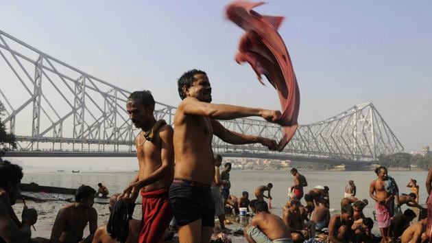 People perform their morning ablutions on a ghat of the Hooghly against the Howrah Bridge. The connectivity brought by the bridge has also lent life to other city landmarks like the Howrah Fish Market which is considered the country’s largest, the Burrabazar commercial hub and Mullick Ghat Flower market which also stakes a claim to the largest of its kind title. (Samir Jana / HT Photo) People perform their morning ablutions on a ghat of the Hooghly against the Howrah Bridge. The connectivity brought by the bridge has also lent life to other city landmarks like the Howrah Fish Market which is considered the country’s largest, the Burrabazar commercial hub and Mullick Ghat Flower market which also stakes a claim to the largest of its kind title. (Samir Jana / HT Photo)