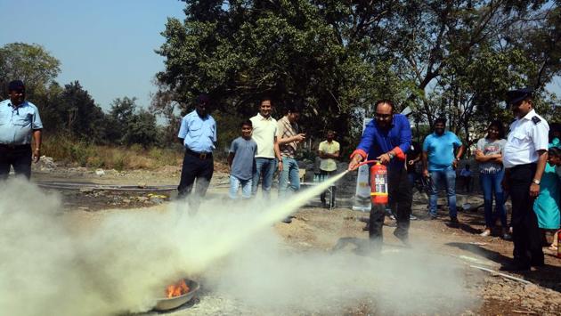 A member of Round Table India tries out a fire extinguisher. (Shankar Narayan/HT PHOTO) A member of Round Table India tries out a fire extinguisher. (Shankar Narayan/HT PHOTO)